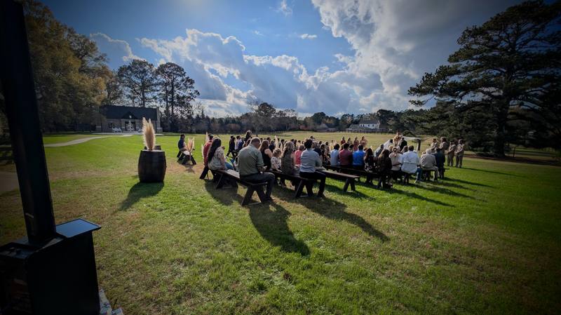 Wide outdoor ceremony from behind the booth